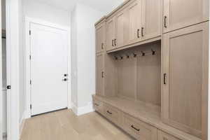 Mudroom featuring light wood-type flooring and baseboards
