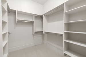 Walk in closet with light colored carpet