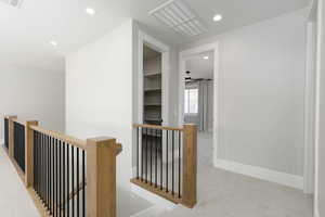 Hallway featuring carpet floors, recessed lighting, and an upstairs landing