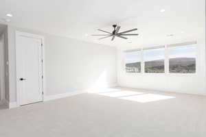 Empty room featuring light colored carpet, a mountain view, recessed lighting, and ceiling fan