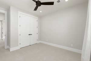 Unfurnished bedroom featuring light colored carpet, recessed lighting, a ceiling fan, and a closet
