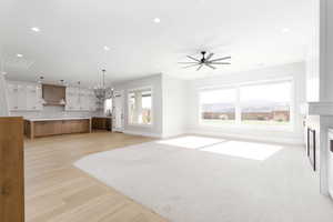Unfurnished living room featuring recessed lighting, light wood finished floors, a fireplace, and ceiling fan