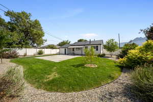 Rear view of house featuring a fenced backyard, a patio area