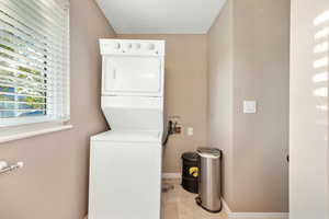 Washroom featuring stacked washer / dryer and baseboards