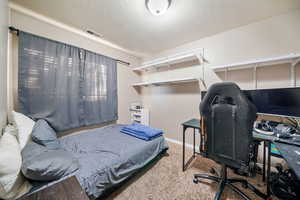 Bedroom with a textured ceiling and carpet floors
