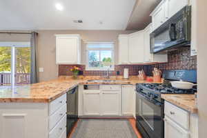 Kitchen with black appliances, decorative backsplash, a peninsula, white cabinets, and recessed lighting