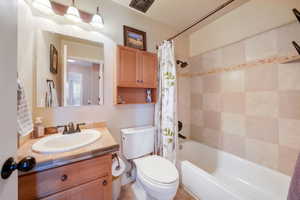 Full bathroom with shower / tub combo with curtain and vanity