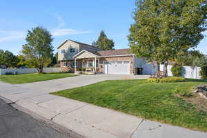 View of front of house with driveway, an attached garage, covered porch, and brick siding