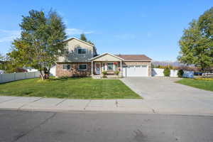 View of front of property with covered porch, concrete driveway, an attached garage, and a mountain view