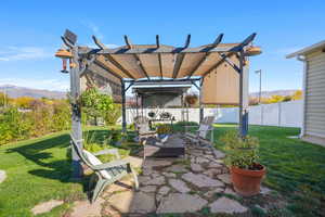 Fenced backyard with a mountain view, a pergola, and a patio