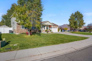 View of front of property with concrete driveway, stone siding, and an attached garage