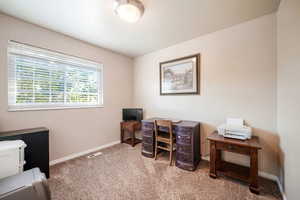 Office space with light colored carpet and baseboards