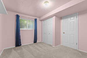 Unfurnished bedroom with carpet flooring, a textured ceiling, and a closet