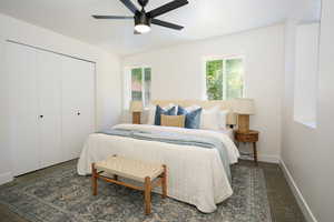 Bedroom featuring dark colored carpet, a ceiling fan, and a closet