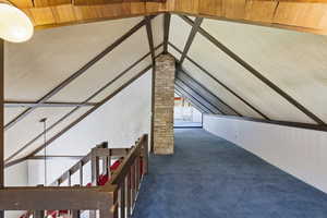 Additional living space with dark carpet