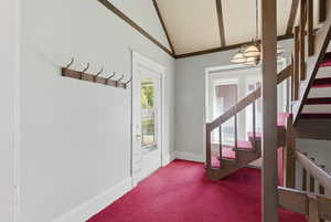 Entryway with stairway, carpet, and a chandelier