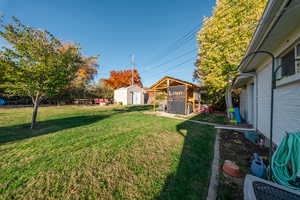 View of grassy yard featuring a storage unit