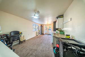 Office area with french doors, a textured wall, light colored carpet, and a textured ceiling