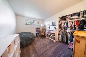 Bedroom with dark colored carpet and a closet
