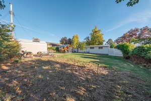 Fenced backyard with an outbuilding