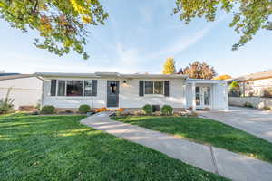 Single story home featuring a front yard, brick siding, and french doors