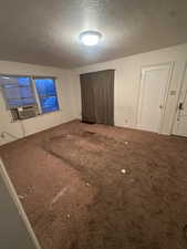 Unfurnished bedroom with carpet floors and a textured ceiling