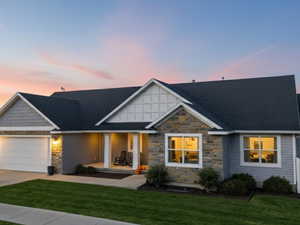 Craftsman house with stone siding, covered porch, driveway, a garage, and a gate