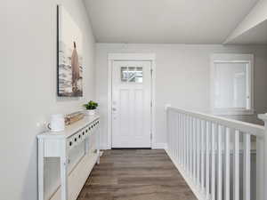 Entrance foyer featuring dark wood-type flooring and lofted ceiling