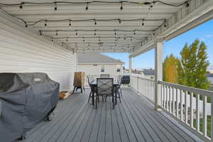 Wooden deck featuring a grill and outdoor dining area