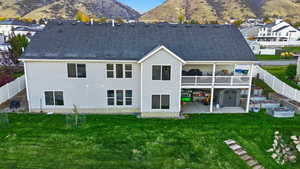 Rear view of property with a fenced backyard, a patio, a shingled roof, and a mountain view