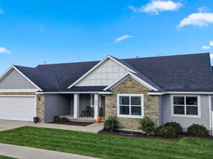Craftsman inspired home with stone siding, roof with shingles, a porch, a gate, and an attached garage