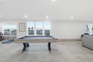 Playroom featuring plenty of natural light, billiards table, recessed lighting, and concrete floors