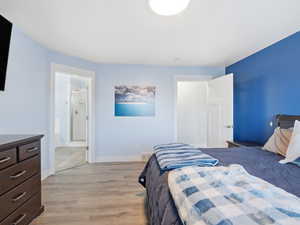 Bedroom featuring light wood-type flooring and ensuite bath