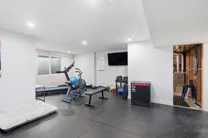 Exercise room featuring recessed lighting, dark flooring, and heating unit