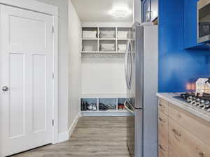 Mudroom with light wood-style flooring and baseboards
