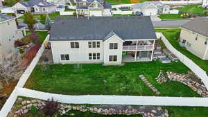 Rear view of house with a patio area, a fenced backyard, a residential view, and a shingled roof