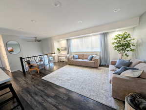 Living room with dark wood-style floors, a ceiling fan, recessed lighting, and a textured ceiling