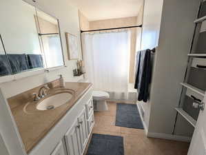 Full bathroom with vanity, shower / tub combo, and light tile patterned floors