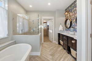 Bathroom featuring a freestanding bath, double vanity, a shower stall, recessed lighting, and a spacious closet