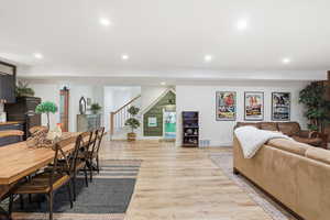 Dining space with recessed lighting, light wood-style flooring, and stairway