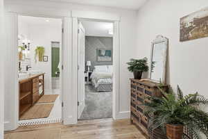 Ensuite bathroom with light wood-style floors and double vanity