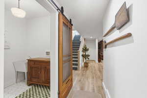 Hall featuring a barn door and baseboards