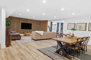 Dining area featuring recessed lighting, wooden walls, and light wood-style floors