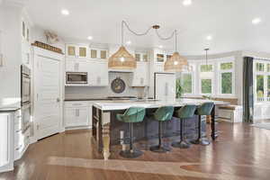 Kitchen featuring white cabinets, dark wood-style floors, hanging light fixtures, backsplash, and recessed lighting