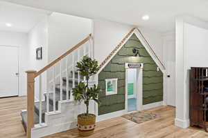 Entryway with wood finished floors, recessed lighting, and stairway