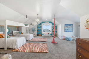 Bedroom with lofted ceiling, carpet floors, and a textured ceiling
