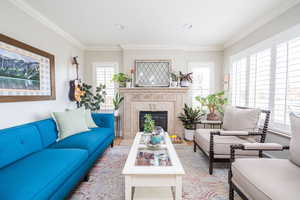 Living room featuring a fireplace, crown molding, and recessed lighting