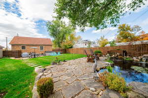 Fenced backyard with a patio area, outdoor dining space, a small pond, and outdoor lounge area
