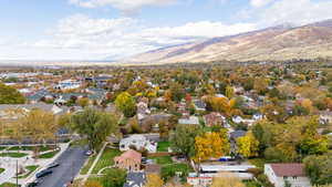 Aerial view of property and surrounding area with a mountain backdrop and nearby suburban area