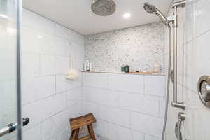 Full bathroom featuring tiled shower and recessed lighting